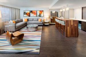达拉斯Dallas Marriott Suites Medical/Market Center的客厅以及带沙发和桌子的厨房。