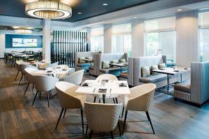 达拉斯Dallas Marriott Suites Medical/Market Center的餐厅设有桌椅和窗户。