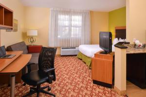 迈阿密湖迈阿密湖广场套房酒店的酒店客房配有一张床、一张书桌和一台电视。