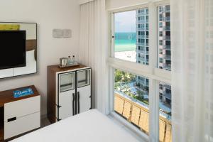 迈阿密海滩迈阿密南滩皇家棕榈尊贵度假酒店的一间卧室设有大窗户,享有海滩美景