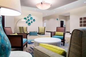 奥兰多TownePlace Suites by Marriott Orlando Theme Parks/Lake Buena Vista的一间设有椅子和桌子的等候室