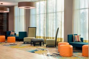 奥兰多TownePlace Suites by Marriott Orlando Theme Parks/Lake Buena Vista的一间设有五颜六色椅子和窗户的等候室