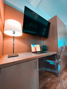 阿尔塔维拉米利恰Principe Alogna Hotel & SPA的客房设有一张带电视和台灯的书桌。