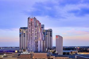 圣安东尼奥San Antonio Marriott Rivercenter on the River Walk的一座高大的建筑,上面有钟