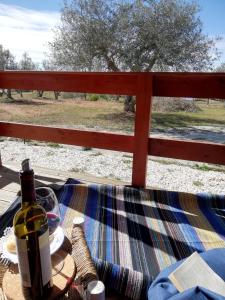 PedrógãoBurrico D`Orada - Lodging & Experiences的坐在桌子上,带围栏的一瓶葡萄酒