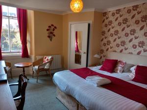 罗撒西阿迪讷宾馆的一间卧室配有一张带红色床单的大床