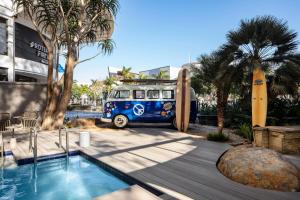 德班Protea Hotel Fire & Ice! by Marriott Durban Umhlanga Ridge的停在游泳池旁的蓝色货车,带有冲浪板
