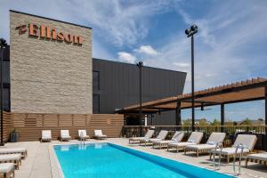 俄克拉何马城The Ellison, Oklahoma City, a Tribute Portfolio Hotel的一个带躺椅的游泳池和一间酒店