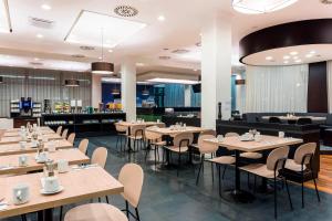 布拉格布拉格机场万怡酒店的一间在房间内配有桌椅的餐厅