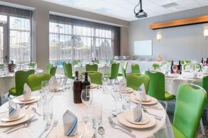 奥兰治比奇SpringHill Suites Orange Beach at The Wharf的一间会议室,配有桌子和绿色椅子
