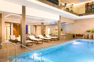 索尔纳AC Hotel by Marriott Stockholm Ulriksdal的酒店大堂设有游泳池和躺椅