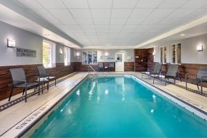 奥克维尔Fairfield Inn by Marriott Toronto Oakville的酒店客房的游泳池配有桌椅