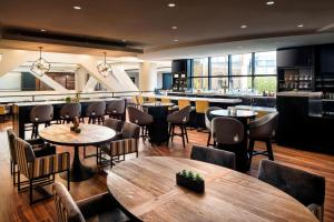 奥克兰奥克兰市中心万豪酒店的一间带桌椅的餐厅和一间酒吧