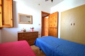 新福卡Casa vacanza vicino spiaggia-ll23的一间卧室配有蓝色的床和木制橱柜