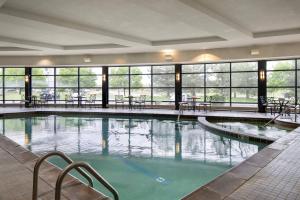 奥罗拉丹佛机场盖特威公园万豪酒店的大楼内带桌椅的大型游泳池