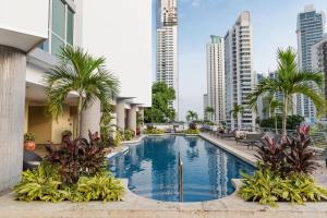 巴拿马城菲尼斯特雷巴拿马城万豪行政公寓 的一座棕榈树和建筑游泳池