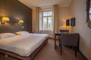 法尔肯堡弗莱彻酒店的一间卧室配有一张床、一张书桌和一台电视