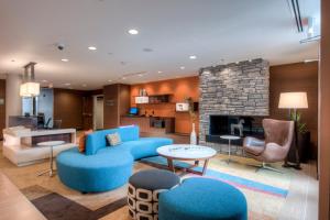 夏洛特万豪夏洛特机场费尔菲尔德客栈的客厅配有蓝色的家具和壁炉