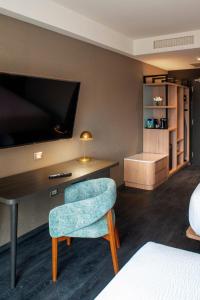 利马Fairfield by Marriott Lima Miraflores的酒店客房设有椅子和电视。