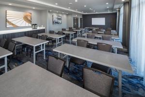 俄克拉何马城Fairfield Inn & Suites by Marriott Oklahoma City Downtown的一间带桌椅和屏幕的用餐室