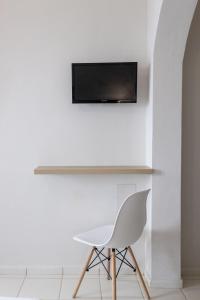 阿德里安诺斯坎波斯凯缇公寓酒店的白色椅子和墙上的电视机