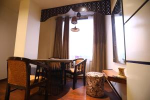 KotdwāraHotel Grand Kailash,Kotdwara的一间带桌椅和窗户的用餐室