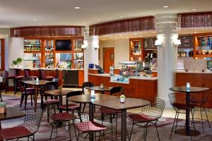 罗切斯特罗彻斯特布赖顿万怡酒店的一间带桌椅的餐厅和一间酒吧