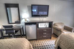 海伦Amerivu Inn & Suites - Helen - Downtown的酒店客房配有电视、书桌和椅子