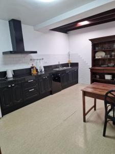 宏达海滩Casa Phitaya的厨房配有黑色橱柜和木桌