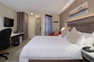 波罗瓜尼波罗克瓦尼地标万豪Protea酒店的酒店客房设有一张白色大床和一张书桌