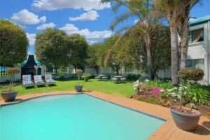 波罗瓜尼波罗克瓦尼地标万豪Protea酒店的棕榈树庭院内的游泳池
