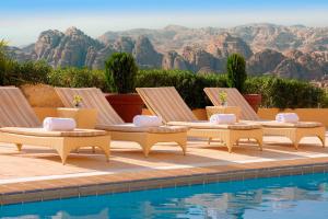 瓦迪穆萨佩特拉万豪酒店的一组四把躺椅,位于游泳池旁
