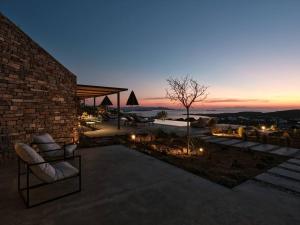 KrotiriOlithos Villas的黄昏时分带两把椅子和灯的庭院