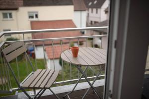 Oedheim1 Zimmer Wohnung DG mit Klimaanlage und kleinen Balkon的坐在阳台上的桌子上,喝杯咖啡