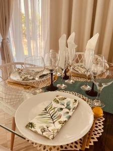 普拉伊拉多比莱尼Casa Conforto Bilene的一张桌子,上面放有盘子和酒杯