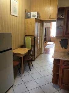 布达佩斯Cozy flat at Stadionok M station的厨房配有桌子、桌子和冰箱。