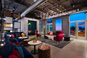 圣安东尼奥Aloft San Antonio UTSA Area的客厅配有蓝色的沙发和红色的椅子