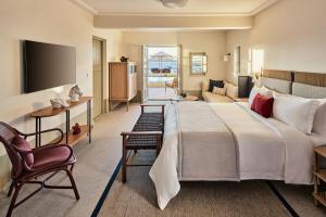 纳乌萨考斯米提斯酒店的酒店客房设有一张大床和一间客厅。