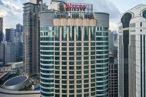 吉隆坡吉隆坡威斯汀酒店的一座高大的建筑,上面有标志