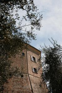 蒙特格里多尔福Palazzo Viviani Castello di Montegridolfo的一座高大的砖砌建筑,上面有窗户