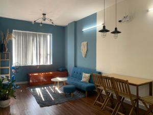 Thôn Mỹ PhướcHOMESTAY KHÁCH SẠN NINH THUẬN的客厅配有蓝色的沙发和桌子