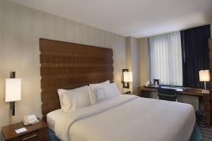 纽约纽约曼哈顿/第五大道万豪费尔菲尔德酒店的酒店客房设有一张大床和一张书桌。