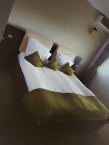 OveseluForest Retreat&Spa的一间卧室配有一张带绿色枕头的床