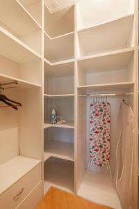 布达佩斯M36 Mester Apartment的配有白色墙壁和白色架子的步入式衣柜