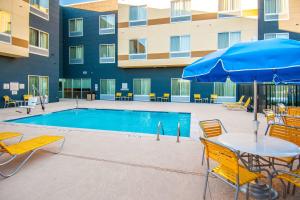 圣安东尼奥圣安东尼奥布鲁克斯城市基地万豪费尔菲尔德客栈酒店的一个带桌椅和遮阳伞的游泳池