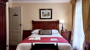 比勒陀利亚Brooklyn Place的一间卧室配有一张带红色毯子的大床
