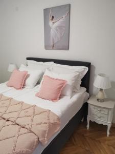 弗尔尼亚奇卡矿泉镇Kuća JEKA的一间卧室配有带粉色和白色枕头的床