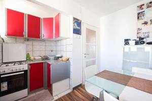 扎达尔Apartman Cruiser的一间设有红色橱柜和一张桌子的小厨房
