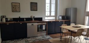 莫内斯捷Domaine et Manoir du Picaud的厨房配有蓝色橱柜和桌椅