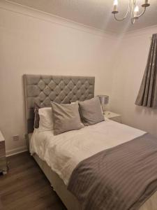 汉密尔顿Flat in Hamilton, South Lanarkshire的一间卧室配有一张大床和大床头板